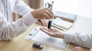 Araba satın alma sözleşmesi ve sigortası, adam arabanın anahtarını, sözleşmeyi imzalayan müşteriye ve anlaşmanın şartlarını teslim etti..