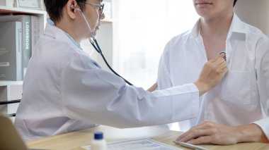 Erkek doktor solunum ve akciğer sağlığını kontrol etmek için stetoskop kullanır, hastanın ilk belirtilerini kontrol etmek için, bir hastane veya klinikte yıllık sağlık kontrolüne katılmak için,.