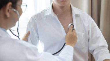 Erkek doktor solunum ve akciğer sağlığını kontrol etmek için stetoskop kullanır, hastanın ilk belirtilerini kontrol etmek için, bir hastane veya klinikte yıllık sağlık kontrolüne katılmak için,.