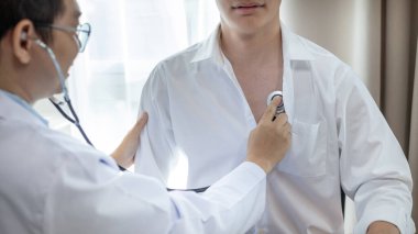 Erkek doktor solunum ve akciğer sağlığını kontrol etmek için stetoskop kullanır, hastanın ilk belirtilerini kontrol etmek için, bir hastane veya klinikte yıllık sağlık kontrolüne katılmak için,.