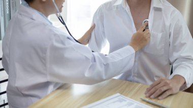 Erkek doktor solunum ve akciğer sağlığını kontrol etmek için stetoskop kullanır, hastanın ilk belirtilerini kontrol etmek için, bir hastane veya klinikte yıllık sağlık kontrolüne katılmak için,.