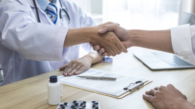 Doktor, hastaları tedavi etmeye gelen ve iyileşen hastaları tebrik etmek için el sıkıştı. Doktor ve hasta, tıbbi tedavi ve sağlık kontrolü arasında tebrik ederim..