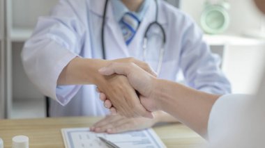 Doktor, hastaları tedavi etmeye gelen ve iyileşen hastaları tebrik etmek için el sıkıştı. Doktor ve hasta, tıbbi tedavi ve sağlık kontrolü arasında tebrik ederim..