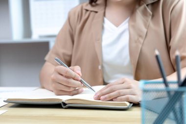 Not defterine not alan Asyalı kadın evde dizüstü bilgisayarda çalışırken, görüntülü sohbet, online iletişim, Evde kal, Yeni Normal, Mesafeli Öğrenme