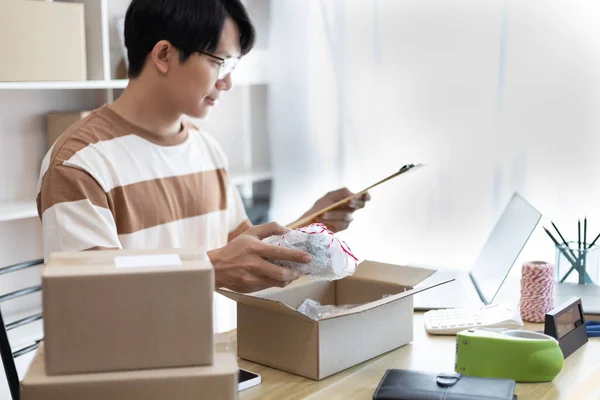 Sell online, Small business owners or SMEs are checking the from notebook items that customers have ordered and preparing the products in the boxes for delivery, Online shopping SME entrepreneur.