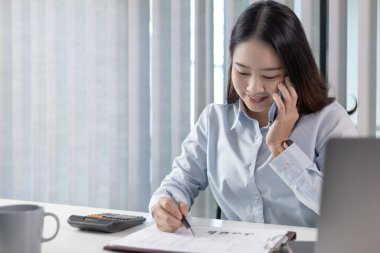 Telefonda konuş, finans çalışanları şirketin finansal verilerini bir dizüstü bilgisayarda gözden geçiriyorlar ve sosyal mesafelerde takımla iletişim kurmak veya sohbet etmek için akıllı telefonlar kullanıyorlar, yalnız çalışıyorlar..