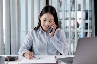 Telefonda konuş, finans çalışanları şirketin finansal verilerini bir dizüstü bilgisayarda gözden geçiriyorlar ve sosyal mesafelerde takımla iletişim kurmak veya sohbet etmek için akıllı telefonlar kullanıyorlar, yalnız çalışıyorlar..