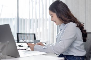 İş kadını, bilgisayarı, teknoloji ve internet iletişimi dünyasında çalışmak için kullanıyor, finansal işlemleri yürütmek için bilgisayar kullanıyor, çünkü kolaylık ve hız.