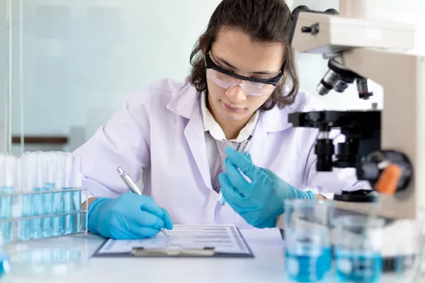 Laboratory diagnosis of synthetic substances, Scientist or researcher examines the substance in vitro and record information, Lab experiments, Researchers scientist working analysis with test tube.