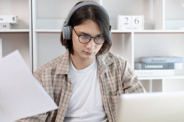 Erkek öğrenci ödevlerini laptopun canlı performans sistemi üzerinden yapıyor, benim ödevim, sınıfta dizüstü bilgisayar ve veri grafikleri kullanarak, çevrimiçi iletişim, sosyal uzaklık....