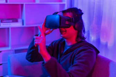 Sanal gerçeklik gözlüğü takan adam heyecan verici bir 3 boyutlu oyun oynuyor, Bluetooth Uzaktan Kumanda, VR, Gelecek Oyunları, Gadget, Teknoloji, Kırmızı ve Mavi arka plan, VR oyun konsepti.