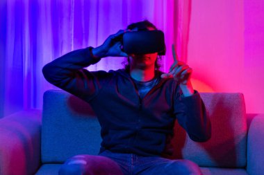 Sanal gerçeklik gözlüğü takan adam heyecan verici bir 3 boyutlu oyun oynuyor, Bluetooth Uzaktan Kumanda, VR, Gelecek Oyunları, Gadget, Teknoloji, Kırmızı ve Mavi arka plan, VR oyun konsepti.