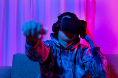 İnsan sanal gerçeklik gözlüğü takar ve eğlenceli, VR, Future Games, Technology, Red and Blue Controller, Touch Controller, Bluetooth Uzaktan Kumanda, VR oyun konsepti ile oyun oynamak için joystick kullanır.