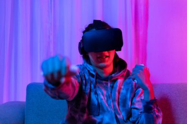 İnsan sanal gerçeklik gözlüğü takar ve eğlenceli, VR, Future Games, Technology, Red and Blue Controller, Touch Controller, Bluetooth Uzaktan Kumanda, VR oyun konsepti ile oyun oynamak için joystick kullanır.