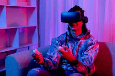 İnsan sanal gerçeklik gözlüğü takar ve eğlenceli, VR, Future Games, Technology, Red and Blue Controller, Touch Controller, Bluetooth Uzaktan Kumanda, VR oyun konsepti ile oyun oynamak için joystick kullanır.