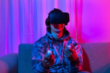 İnsan sanal gerçeklik gözlüğü takar ve eğlenceli, VR, Future Games, Technology, Red and Blue Controller, Touch Controller, Bluetooth Uzaktan Kumanda, VR oyun konsepti ile oyun oynamak için joystick kullanır.