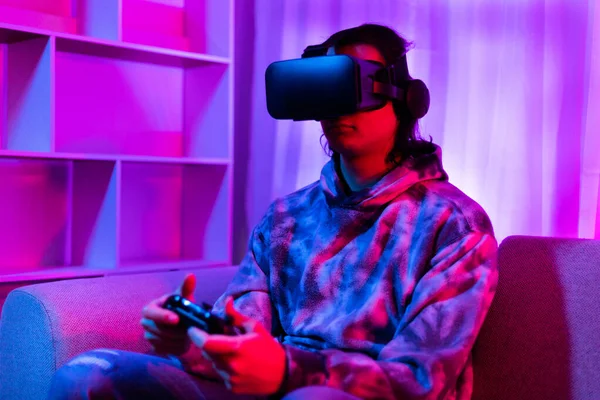 Adam sanal gerçeklik gözlüğü takıyor ve eğlence için joystick kullanıyor, sanal gerçeklik gözlüklü erkek, VR, gelecek oyunları, Gadgets, Teknoloji, kırmızı ve mavi arka plan, VR oyun konsepti. 
