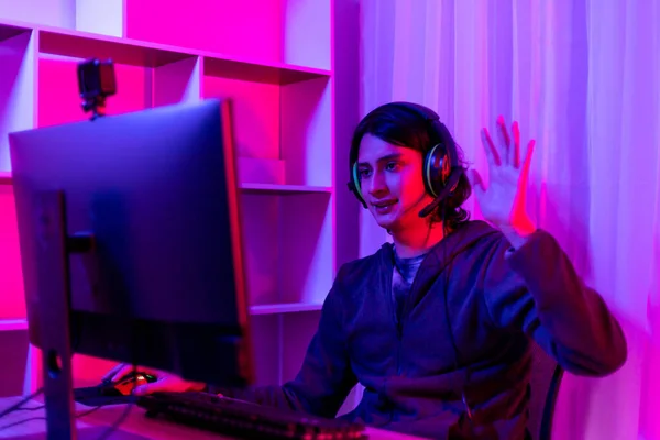 Men play E-Sport games or streamers, Waving to the audience, Male enjoying playing online games, Entertainment  or technology game trends, Professional live performance, Red and blue background.