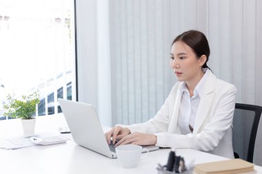 İş kadını çalışmak için dizüstü bilgisayar kullanıyor, ofiste çalışan Asyalı kadın, teknoloji ve internet iletişimi dünyası, finansal işlemleri yürütmek için bilgisayar kullanıyor..