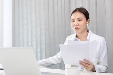 Genç Asyalı kadınlar video sohbetleri yoluyla arkadaş ve menajerleriyle konuşuyor ve onları neşeli ifadelerle selamlıyor, İnternet üzerinden iletişim, Evde kal, Yeni Normal, VDO Çağrısı, İnternet.