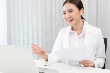 Genç Asyalı kadınlar video sohbetleri yoluyla arkadaş ve menajerleriyle konuşuyor ve onları neşeli ifadelerle selamlıyor, İnternet üzerinden iletişim, Evde kal, Yeni Normal, VDO Çağrısı, İnternet.