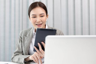 Ofiste çalışmak için tablet kullanan bir iş kadını.