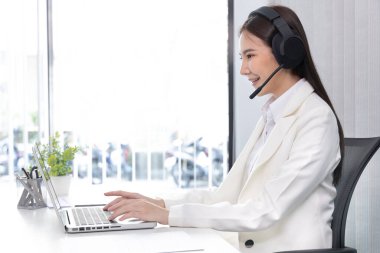 Çağrı merkezinde çalışan telsiz operatörü, hizmetlere, müşteri hizmetlerine, bilgilendirmeye, çağrı merkezine ihtiyacı olan müşterilere sohbet ediyor veya tavsiyelerde bulunuyor.