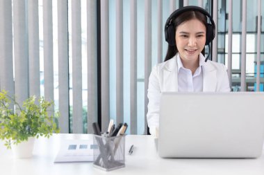 Çağrı merkezinde çalışan telsiz operatörü, hizmetlere, müşteri hizmetlerine, bilgilendirmeye, çağrı merkezine ihtiyacı olan müşterilere sohbet ediyor veya tavsiyelerde bulunuyor.