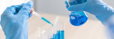 Bilim insanları kimyasal bileşimin ve biyolojik kütlesinin bilimsel bir laboratuvarda, bilim adamlarında ve laboratuar konseptinde tespit edilmesine hazırlanmak için mavi kimyasal test tüpleri taşıyorlar..