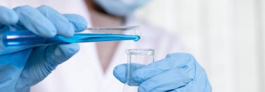 Bilim insanları kimyasal bileşimin ve biyolojik kütlesinin bilimsel bir laboratuvarda, bilim adamlarında ve laboratuar konseptinde tespit edilmesine hazırlanmak için mavi kimyasal test tüpleri taşıyorlar..