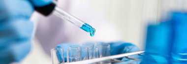 Bilim insanları kimyasal bileşimin ve biyolojik kütlesinin bilimsel bir laboratuvarda, bilim adamlarında ve laboratuar konseptinde tespit edilmesine hazırlanmak için mavi kimyasal test tüpleri taşıyorlar..