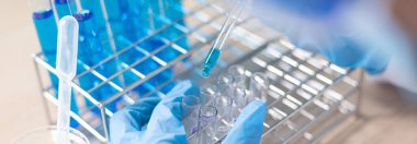 Bilim insanları kimyasal bileşimin ve biyolojik kütlesinin bilimsel bir laboratuvarda, bilim adamlarında ve laboratuar konseptinde tespit edilmesine hazırlanmak için mavi kimyasal test tüpleri taşıyorlar..