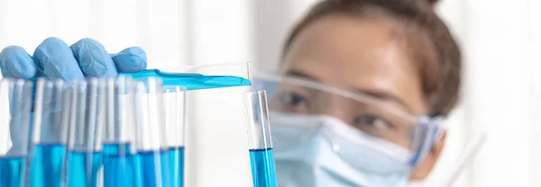 科学者たちは 研究室での化学組成と生物学的質量の決定のために準備するために青色の化学試験管を持っています 研究室での科学者や研究コンセプト — ストック写真
