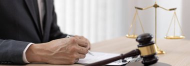 Yargıç ya da avukat mahkeme salonunda belgeler üzerinde çalışır ve adalet, doğruluk, dava ve adalet kavramları için çeşitli yasaları analiz eder..