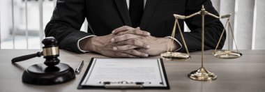 Yargıç ya da avukat mahkeme salonunda belgeler üzerinde çalışır ve adalet, doğruluk, dava ve adalet kavramları için çeşitli yasaları analiz eder..