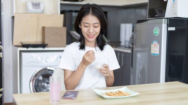 Yarı Japon kadın kahvaltıda mısır gevreğiyle yoğurt yiyor, sağlıklı yiyecekler ve sindirim sistemi bakımı en popüler ve en kolay kahvaltılık yiyecekler..