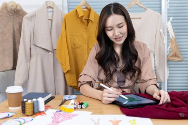Tasarım stüdyosundaki tablet, moda tasarımcısı, yaratıcılık ve fikirler, manken, tişört çizimi, renk düzeni, giysi aksesuarları aracılığıyla profesyonel kadın tasarımcı kıyafetleri tasvir etme, bağımsız çalışma.