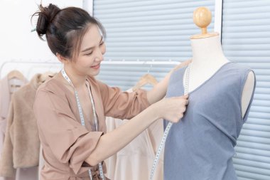 Profesyonel kadın tasarımcılar, stüdyodaki gömlek mankenleri, moda tasarımcıları, yaratıcılık ve fikirler, manken eskizi, renk şeması, giysi aksesuarları etrafında mezura kullanırlar..