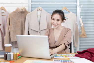 Professional female designer sketches of clothes through laptop in the design studio, Fashion designer, Creativity and ideas, Mannequin, Shirt sketch, Color scheme, Garment accessories ,Freelance.
