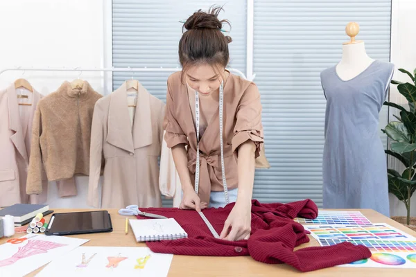 Professional female designers use a tape measure around the shirt in the studio, Fashion designer, Creativity and ideas, Mannequin, Shirt sketch, Color scheme, Garment accessories.