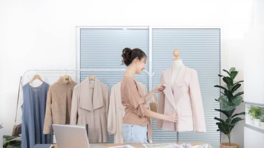 Profesyonel kadın tasarımcılar, stüdyodaki gömlek mankenleri, moda tasarımcıları, yaratıcılık ve fikirler, manken eskizi, renk şeması, giysi aksesuarları etrafında mezura kullanırlar..