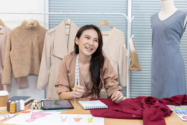 Professional designer sits at her desk thinking about fashion design ideas in her studio, Fashion designer, Creativity and ideas, Mannequin, Shirt sketch, Color scheme, Garment accessories.