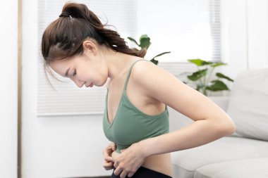 Woman in a gym clothes uses a centimeter strap to measure her circumference thin waist, Thin waist female, Health care concept and weight control, Sports waist, Healthy lifestyle, Physical activity.