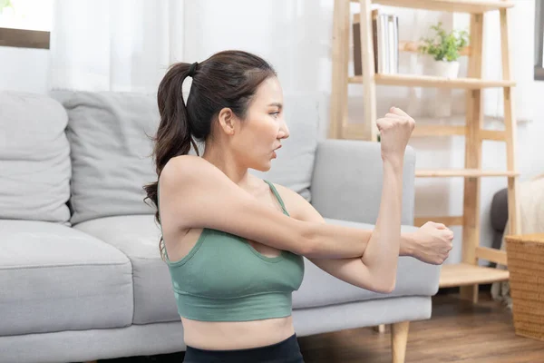 Slim Asian woman doing yoga meditation at home, Stretching the muscles of the body and practicing proper breathing, Yoga studio, Wearing sportswear, Healthy lifestyle, Exercise concept.