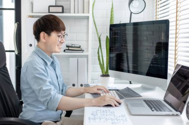 Profesyonel geliştirme programcıları, bilgisayar-laptop-tablet gibi çalışma ekipmanlarıyla bir masada otururlar. Web sitesi, HTML, javascript, Yazılım üzerinde çalışmak veya kod yazmak için.
