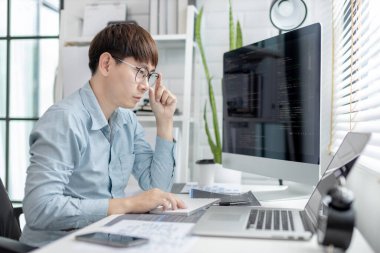 Profesyonel geliştirme programcıları, bilgisayar-laptop-tablet gibi çalışma ekipmanlarıyla bir masada otururlar. Web sitesi, HTML, javascript, Yazılım üzerinde çalışmak veya kod yazmak için.