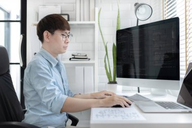 Profesyonel geliştirme programcıları, bilgisayar-laptop-tablet gibi çalışma ekipmanlarıyla bir masada otururlar. Web sitesi, HTML, javascript, Yazılım üzerinde çalışmak veya kod yazmak için.