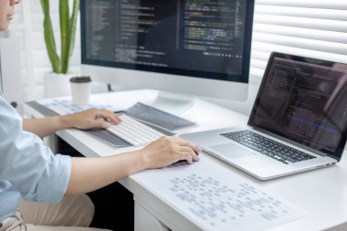 Profesyonel geliştirme programcıları, bilgisayar-laptop-tablet gibi çalışma ekipmanlarıyla bir masada otururlar. Web sitesi, HTML, javascript, Yazılım üzerinde çalışmak veya kod yazmak için.