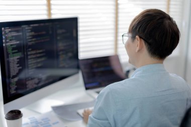Profesyonel geliştirme programcıları, bilgisayar-laptop-tablet gibi çalışma ekipmanlarıyla bir masada otururlar. Web sitesi, HTML, javascript, Yazılım üzerinde çalışmak veya kod yazmak için.