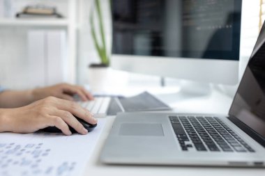 Profesyonel geliştirme programcıları, bilgisayar-laptop-tablet gibi çalışma ekipmanlarıyla bir masada otururlar. Web sitesi, HTML, javascript, Yazılım üzerinde çalışmak veya kod yazmak için.